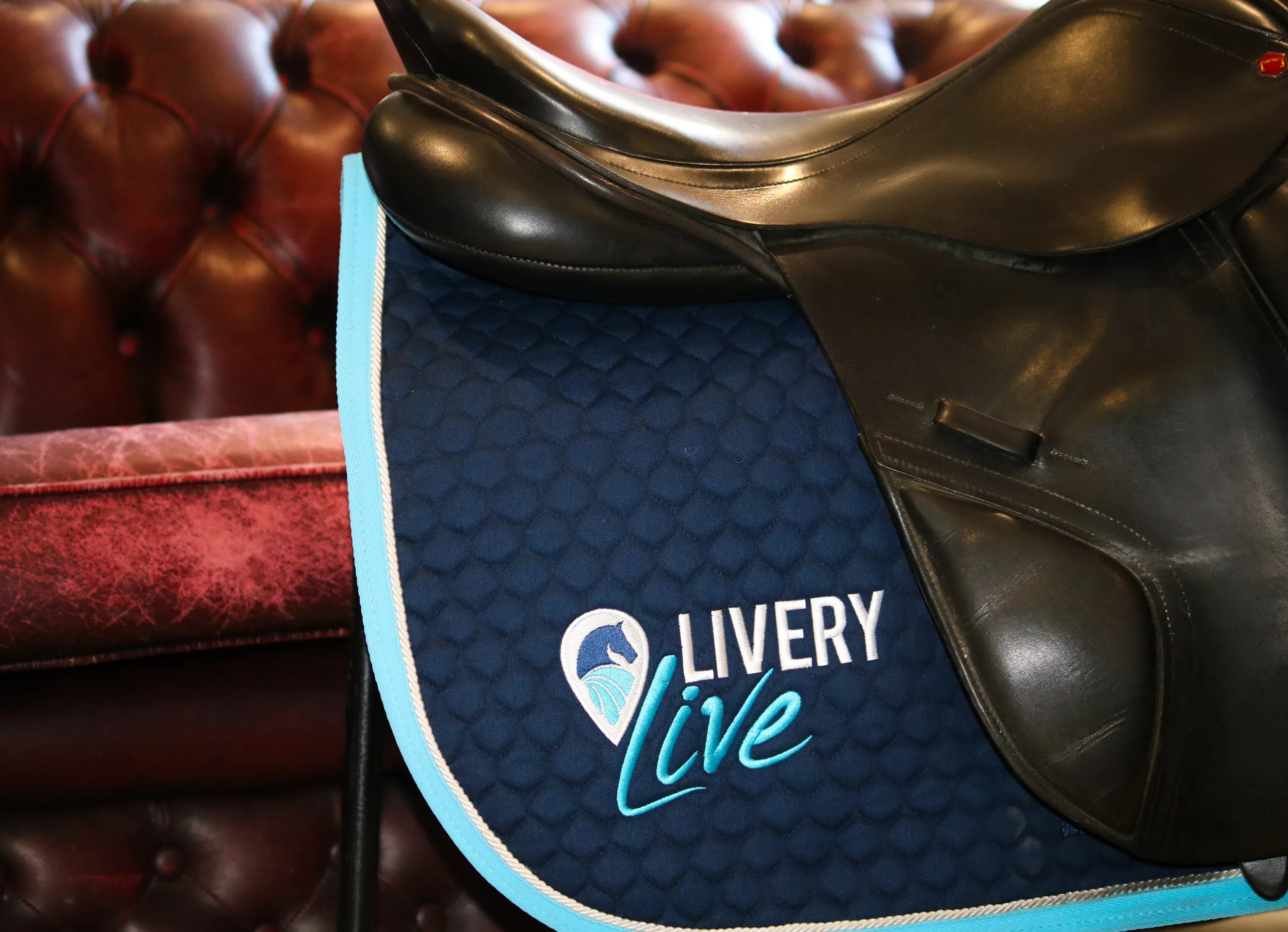 Image shows a horse's sadle with the LIVERYLive logo on it